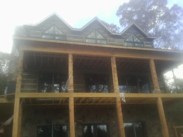 Dormers and porch framing on a large log home under construction — Roof Coating work by our crew in Frostburg