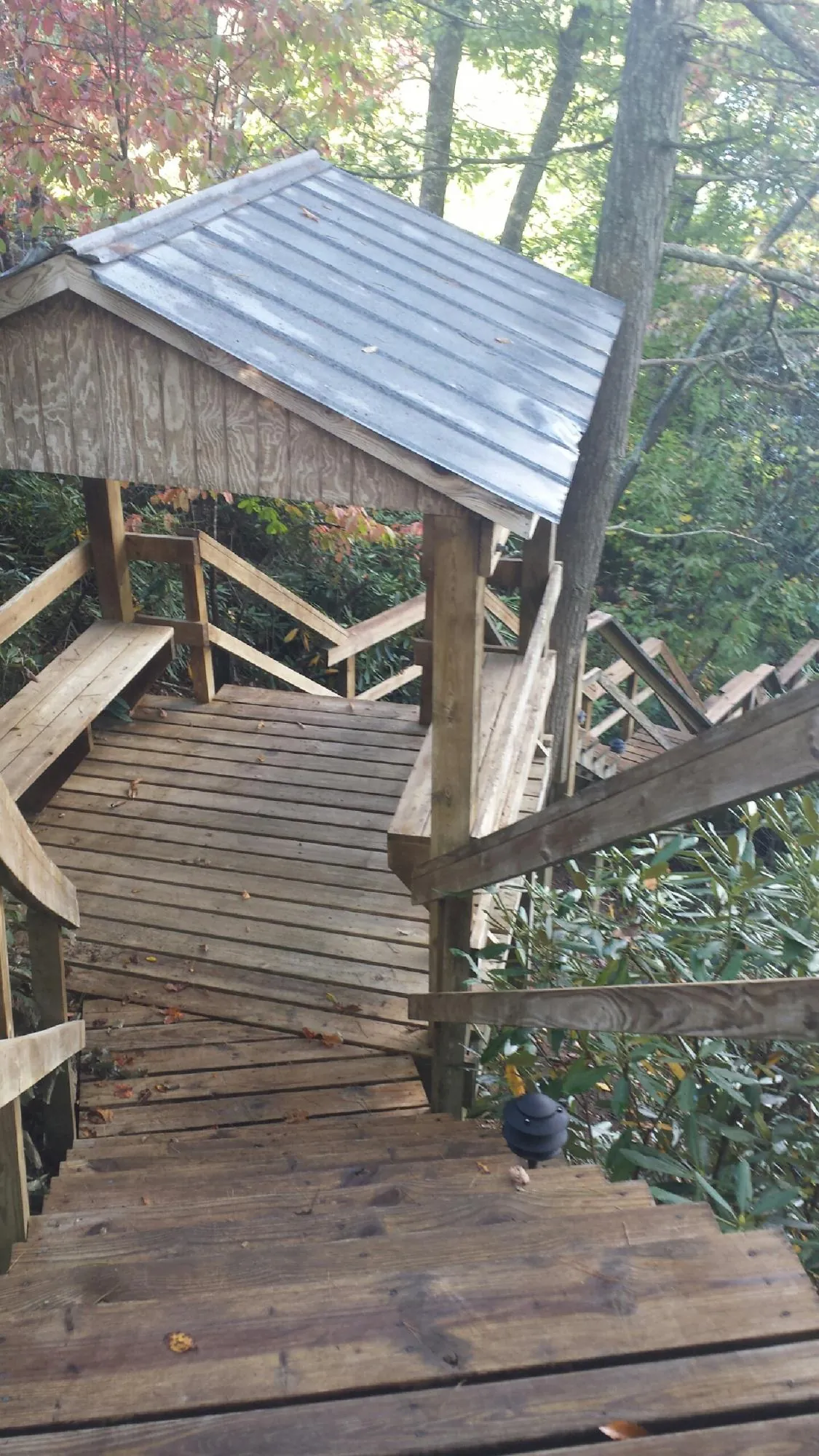 Metal roofed shelter over wooden steps on a wooded walkway — Skylight Repair & Installation work by our crew in Frostburg