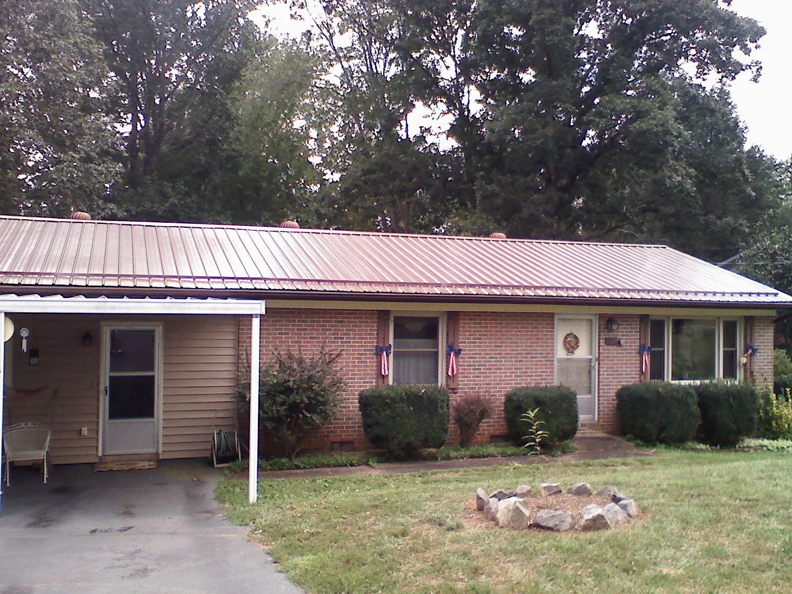 Bronze metal roof and carport on a brick ranch home — Roof Repair work by our crew in Frostburg