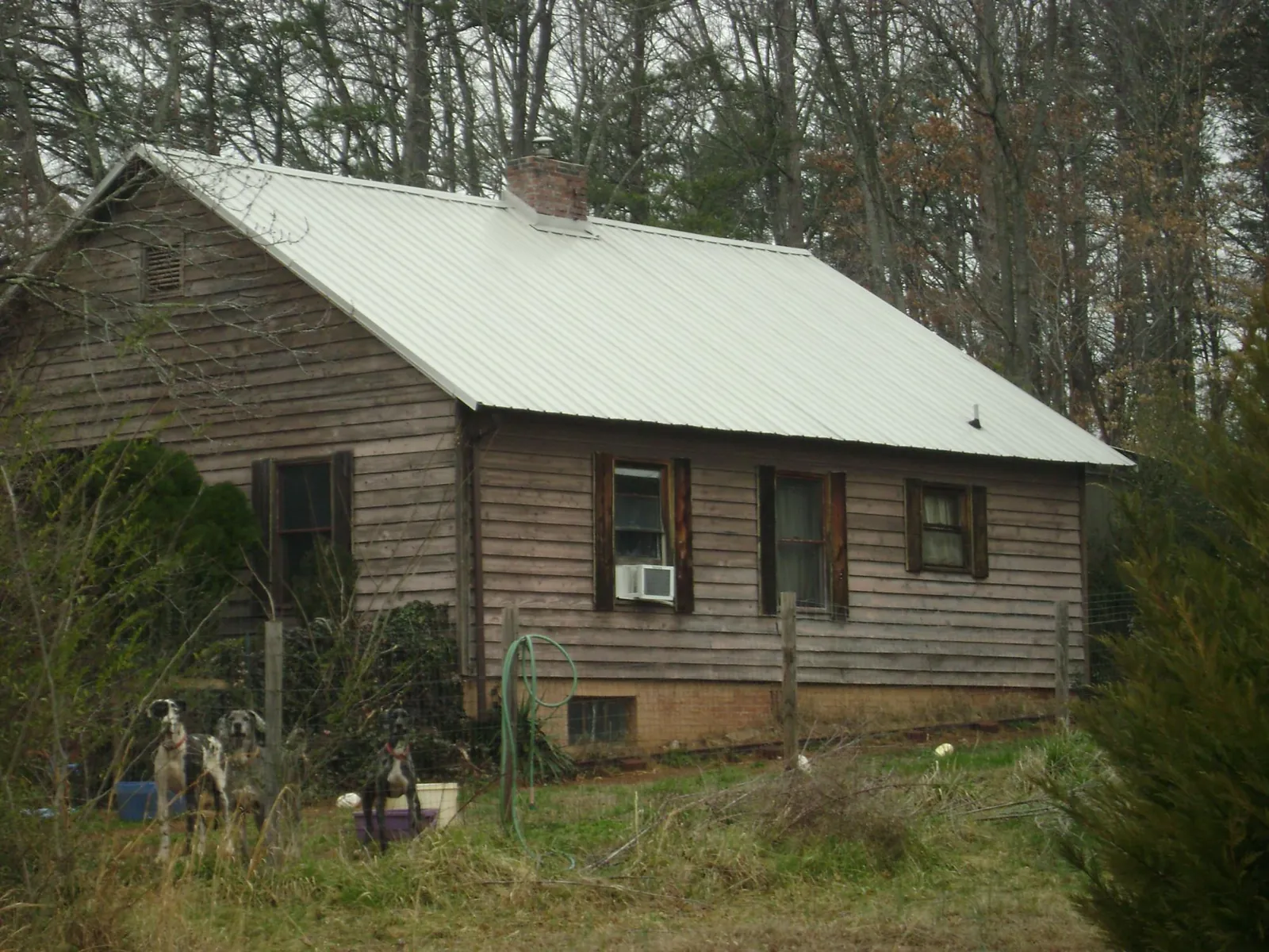 White metal roof on an old wood sided farmhouse, from a Metal Roof Installation job in Frostburg
